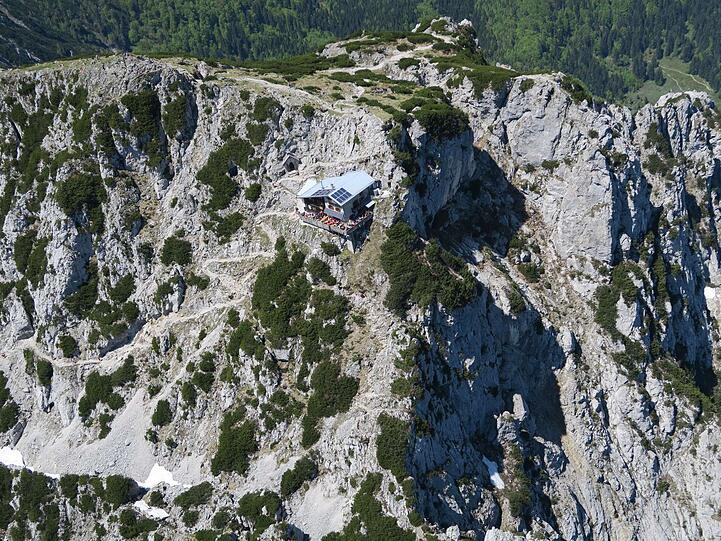 Im mächtigen Bergmassiv wirkt die Hütte wie ein Puppenhaus.