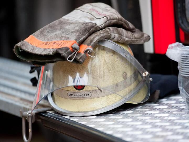 Ein Feuerwehrhelm liegt an einem Einsatzfahrzeug. Foto: picture alliance/dpa/Archivbild