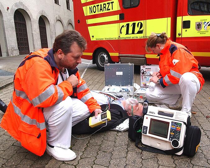 Sanitäter kümmern sich um einen Herzinfarkt-Patienten.