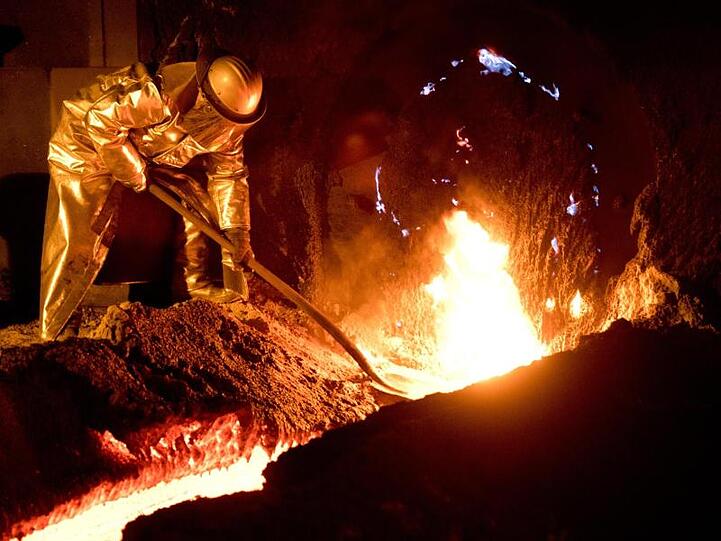 Mitarbeiter in Schutzkleidung arbeiten an einem Hochofen im Stahlwerk in Salzgitter.