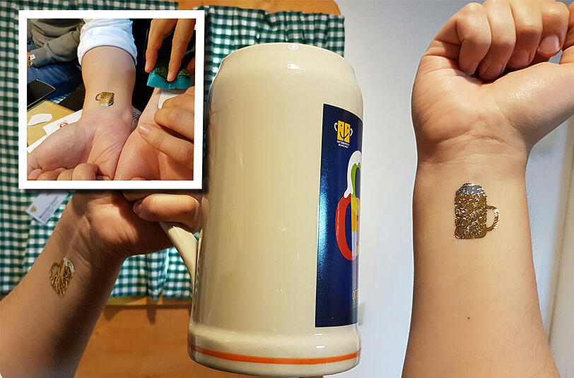 Bei den Wiesn-Narrischen von Universum Oktoberfest, die Führungen über die Wiesn anbieten, lässt sich ein Kollege der AZ-Reporterin ein Wiesn-Tattoo verpassen. Und das, wo das Fest noch keine zwei Stunden alt ist...