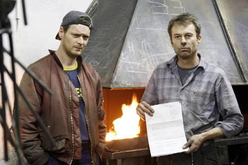 Müssen 2000 Euro mehr Gewerbesteuer bezahlen: Stefan Szekessy und Ralf Ehlers (r.) mit dem Bescheid in ihrer Werkstatt.