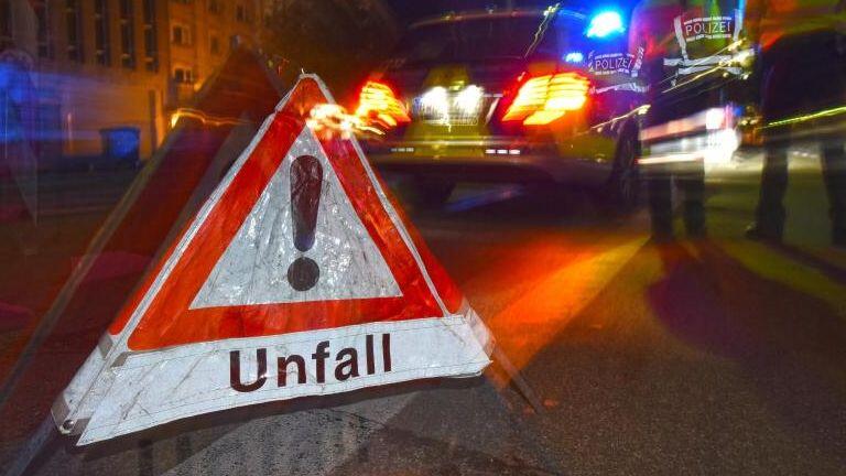 Ein Warndreieck mit dem Schriftzug "Unfall" steht vor einem Polizeifahrzeug. Foto: Patrick Seeger/dpa/Illustration