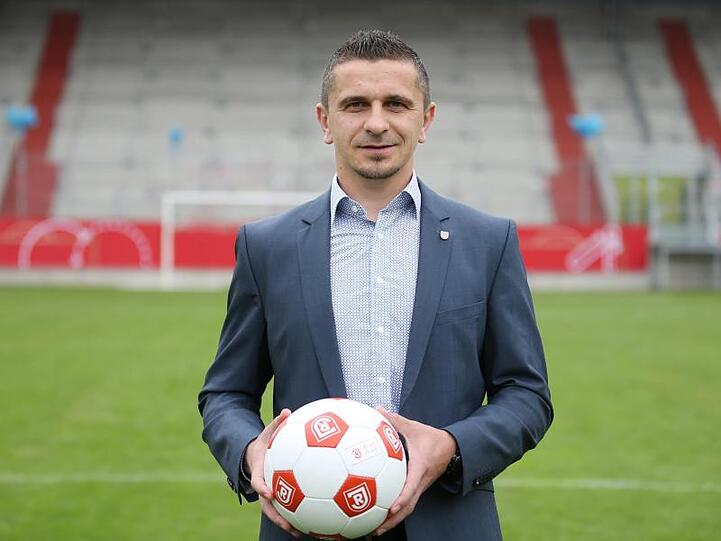 Der Trainer des SSV Jahn Regensburg, Mersad Selimbegovic, hält einen Ball in der Hand. Foto: Andreas Nickl/Archivbild