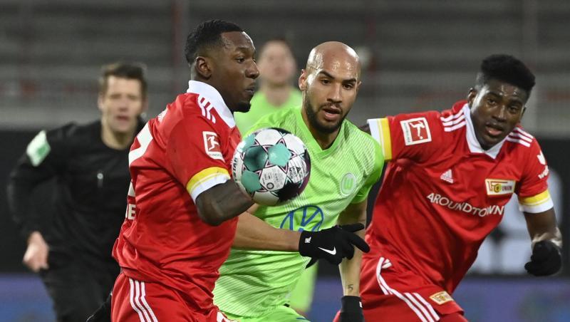 Unions Sheraldo Becker (l-r), Wolfsburgs John Brooks und Unions Taiwo Awoniyi kämpfen um den Ball.