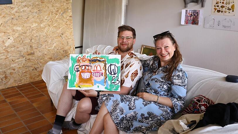 Tobias Sehr und Josephine Kaiser zeigen das Porträt, das von ihnen gemalt wurde.