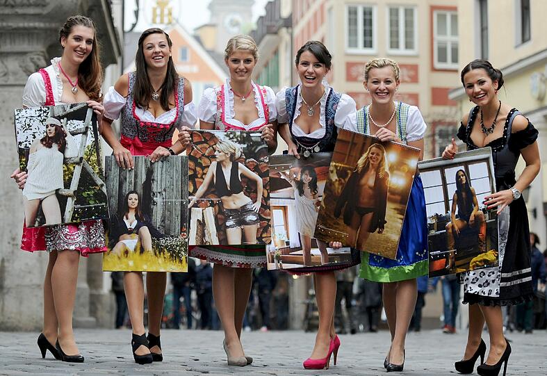 Die Models Kathrin, Kerstin, Eva-Maria, Anita, Theresa und Christiane posieren mit ihren Bildern aus dem Jungbauern-Kalender vorm Hofbräuhaus in München.