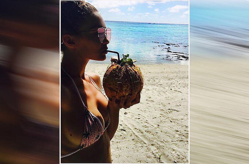 Model Gigi Hadid erfrischt sich mit einer Kokusnuss.