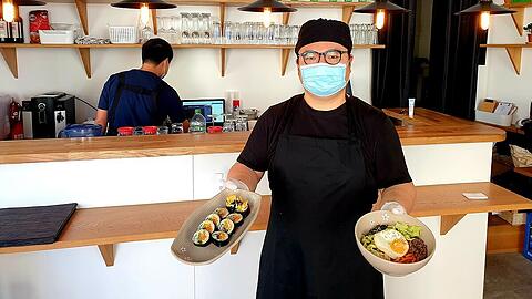 Kyung-Min Hwang mit dem sushiähnlichen Kimbap und Bibimbap.
