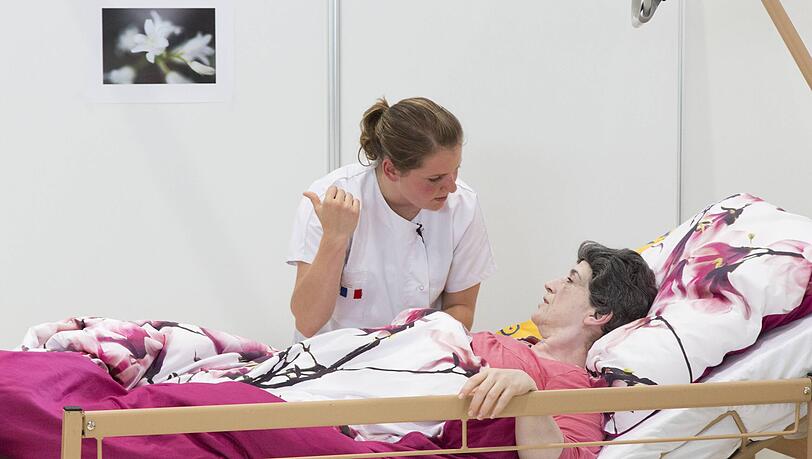 Pflegekraft betreut eine Patientin im Krankenhausbett &ndash; medizinische Berufe werden gefragter.