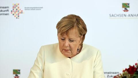 Angela Merkel trägt sich vor Beginn des Festakts in das Goldene Buch der Stadt Halle ein.