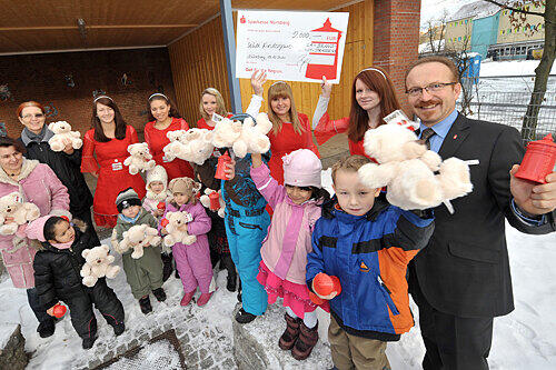 Hurra! Die Kindergarten-Kinder freuten sich über den Besuch der Roten Sparkassen-Engel. Otfried Bürger (r.) übergab den Scheck.