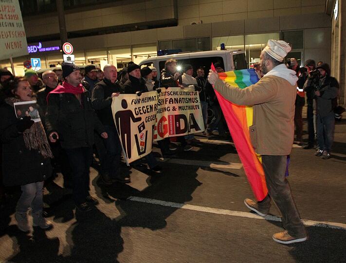 Ein Gegendemonstrant mit einer PACE-Flagge stellt sich den Teilnehmern der islamkritischen Bewegung «Leipzig gegen die Islamisierung des Abendlandes» (Legida) am 21.01.2015 in Leipzig (Sachsen) entgegen.