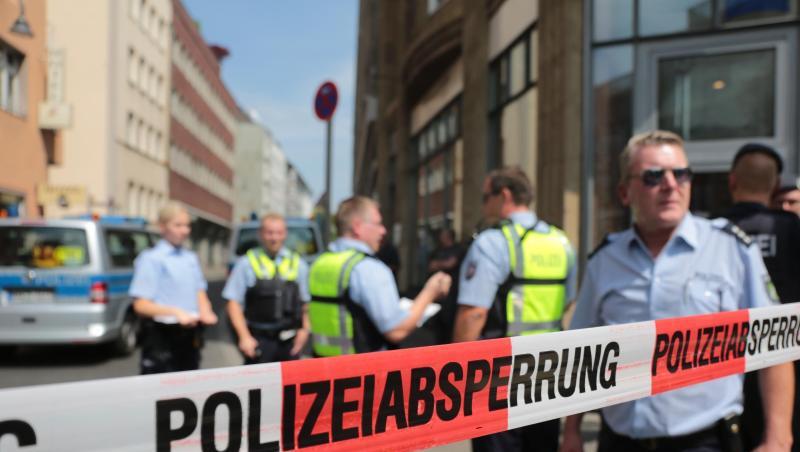 Polizisten stehen vor einem Wohngebäude eines der mutmaßlichen Gefährder in der Kölner Innenstadt hinter einem Absperrband. Polizisten stehen vor einem Wohngebäude eines der mutmaßlichen Gefährder in der Kölner Innenstadt hinter einem Absperrband.
