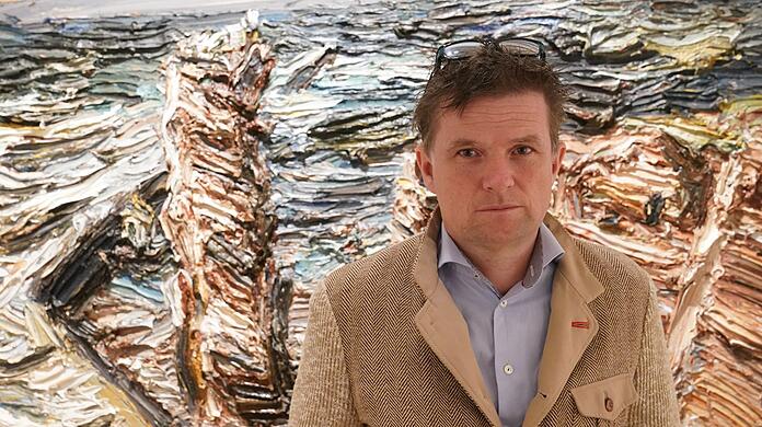 Der Berliner Künstler Christopher Lehmpfuhl steht vor seinem Helgolandbild „Sturm an der Langen Anna. 2014.“