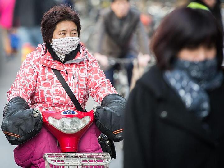Schals und Atemmasken gehören in Peking mittlerweile zum Stadtbild.