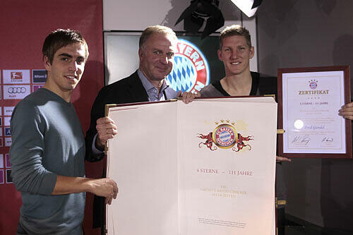 Vorstandsboss Karl-Heinz Rummenigge und die Spieler Philipp Lahm und Bastian Schweinsteiger mit der Bayern-Chronik.