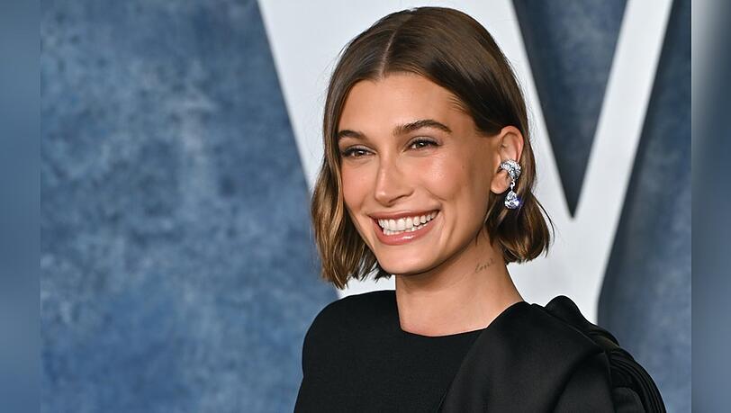 Hailey Bieber gehört zur Gen Z und trägt ihr Haar oft mit Mittelscheitel, was gut zu ihrem eher eckigen Gesicht passt.