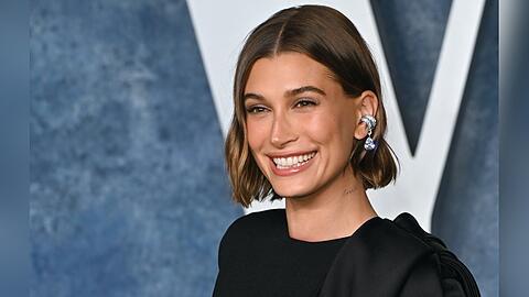 Hailey Bieber gehört zur Gen Z und trägt ihr Haar oft mit Mittelscheitel, was gut zu ihrem eher eckigen Gesicht passt.