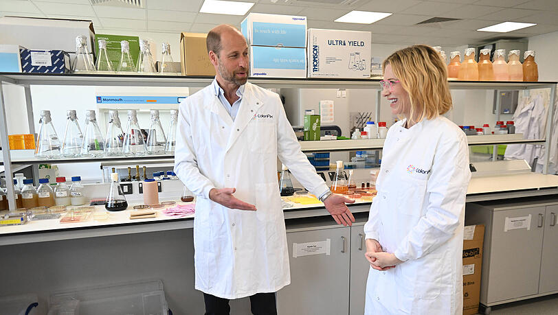 Prinz William flucht während einem Firmenbesuch im englischen Norwich. Seine prominente Begleitung, Hollywood-Schauspielerin Cate Blanchett, bringt er damit zum Lachen.