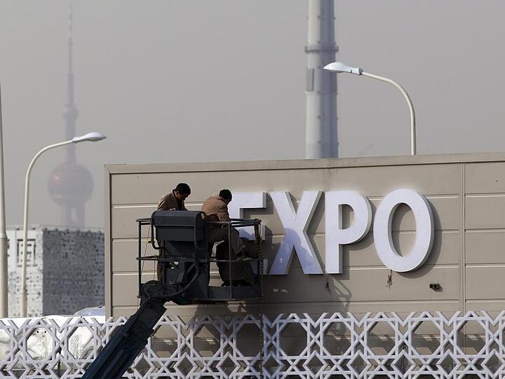 Arbeiter legen letzte Hand an einen Pavillon der Expo
