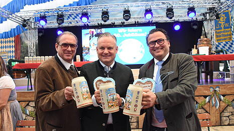 Hier pr&auml;sentiert Wirtschaftsreferent Christian Scharpf (M., SPD) zusammen mit den Schaustellern Robert Eckl (l.) und Peter Bausch stolz den KI-Krug.