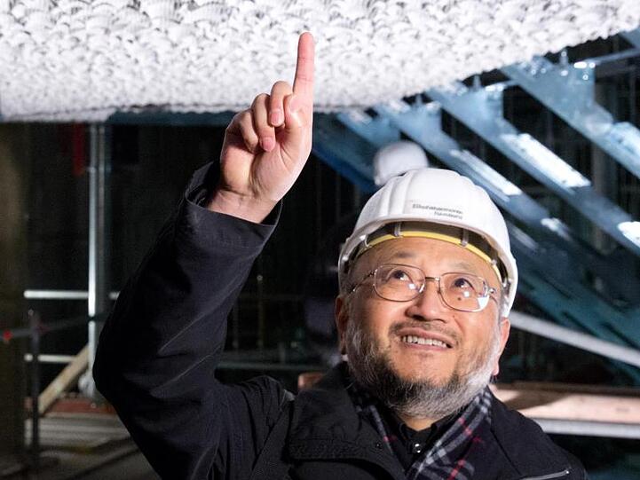 Der für die Akustik der Elbphilharmonie zuständige Japaner Yasuhisa Toyota steht auf einer Montageebene. Foto: Christian Charisius/Archiv