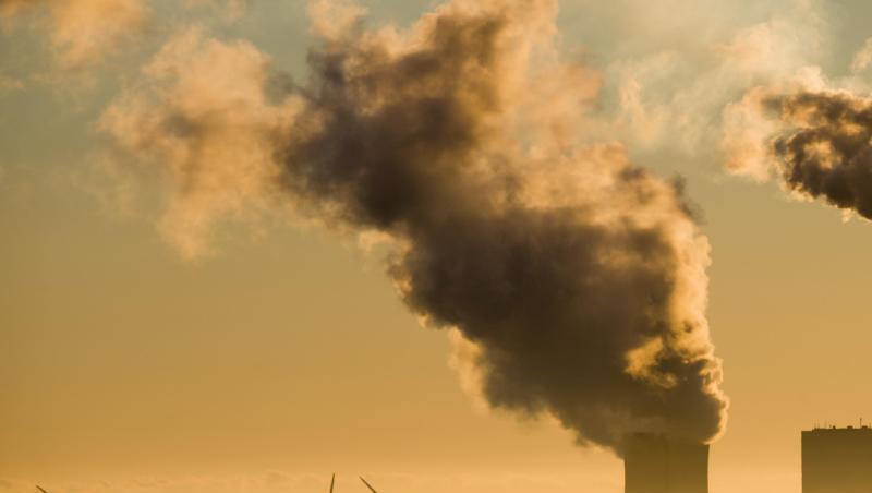 Vergangenheit und Zukunft: Windräder drehen sich hinter einem Kohlekraftwerk. Vergangenheit und Zukunft: Windräder drehen sich hinter einem Kohlekraftwerk.