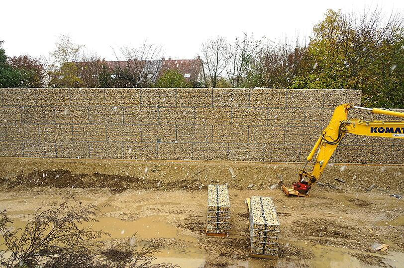 Die Mauer bei der Flüchtlingsunterkunft in der Nailastraße in Neuperlach, im Hintergrund die Häuser von Anwohnern.