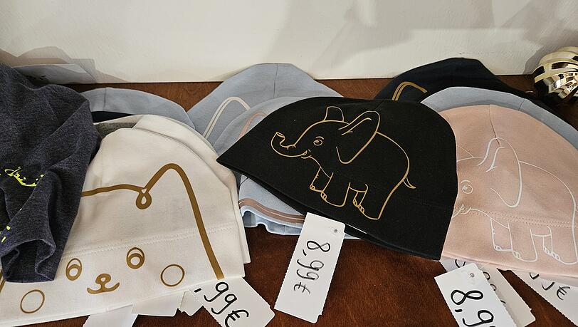 Auch Textilien, wie Kindermützen, Shirts oder Stofftaschen sind zu haben. Auch Textilien, wie Kindermützen, Shirts oder Stofftaschen sind zu haben.