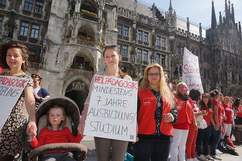 Erzieherinnen, Mütter und Sozialarbeiterinnen und Unterstützer bei Menschenkette am Marienplatz in München.