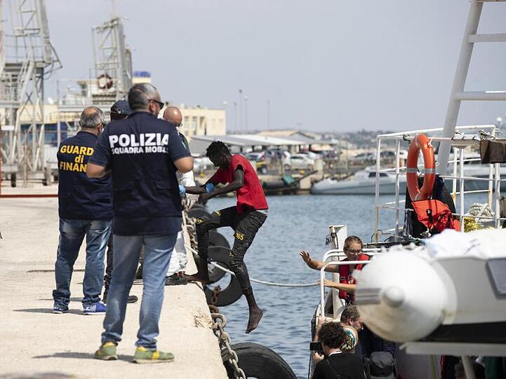Migranten verlassen die "Eleonore" im Hafen von Pozzallo.
