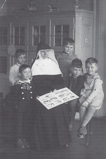 Der kleine Richard (rechts hinten) anno dazumal, gut behütet von Schwester Stanislava.