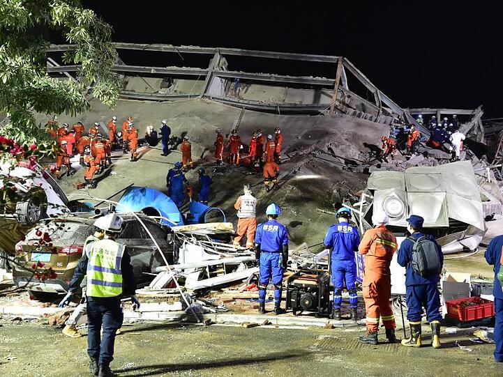 Rettungskräfte arbeiten an der Unfallstelle des eingestürzten Hotels.