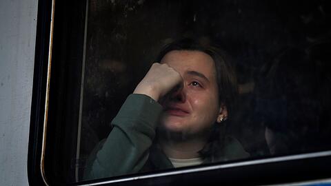 Eine ukrainische Frau sitzt am Hauptbahnhof von Lwiw in einem Zug nach Polen.