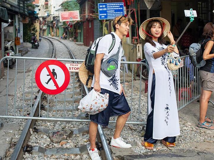 Ein Paar macht ein Selfie an der Absperrung zur "Train Street": Touristen müssen sich in Hanoi von der berühmt gewordenen Sehenswürdigkeit verabschieden.