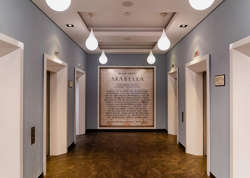 Der Gründungsmythos: An den sechs Aufzügen im Erdgeschoss ist die Plakette in die Wand eingelassen, die erklärt, warum das Haus seinen Namen bekam. Der Gründungsmythos: An den sechs Aufzügen im Erdgeschoss ist die Plakette in die Wand eingelassen, die erklärt, warum das Haus seinen Namen bekam.