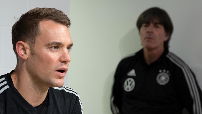 Torhüter Manuel Neuer beantwortet die Fragen von Journalisten, während Joachim Löw, wartet.
