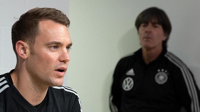 Torhüter Manuel Neuer beantwortet die Fragen von Journalisten, während Joachim Löw, wartet.