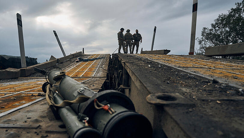 Ukrainische Soldaten stehen auf einer zerstörten Brücke in der Region Charkiw. Ukrainische Soldaten stehen auf einer zerstörten Brücke in der Region Charkiw.