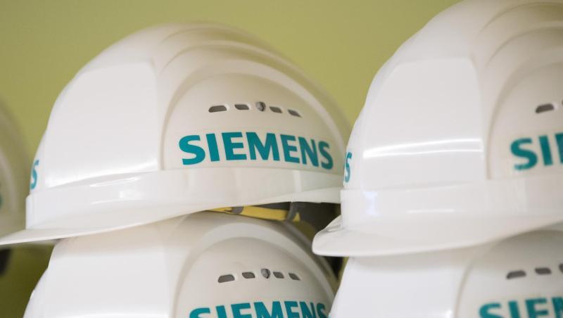 Weiße Schutzhelme mit dem Aufdruck "Siemens" liegen in einem Regal. Foto: Sebastian Kahnert/Archivbild Weiße Schutzhelme mit dem Aufdruck "Siemens" liegen in einem Regal. Foto: Sebastian Kahnert/Archivbild