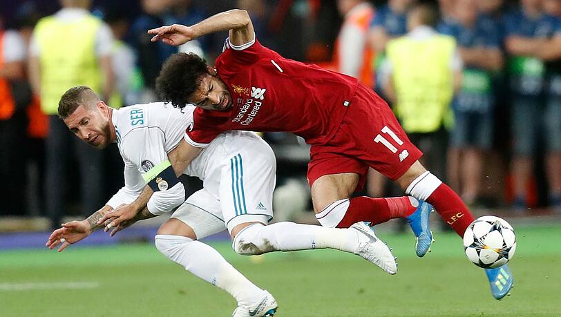Sergio Ramos (l.) klammert den Arm von Mohamed Salah ein. Der Ägypter fällt anschließend auf die Schulter und muss verletzt ausgewechselt werden. Sergio Ramos (l.) klammert den Arm von Mohamed Salah ein. Der Ägypter fällt anschließend auf die Schulter und muss verletzt ausgewechselt werden.