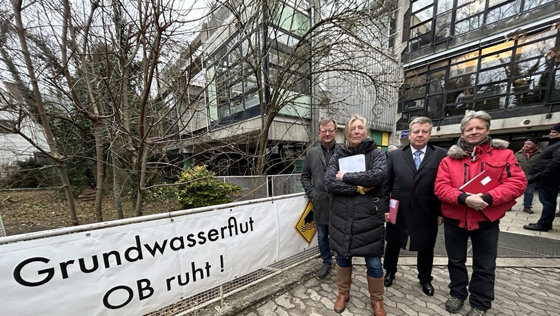 Landtagsabgeordneter Christian Hierneis, Anwohnerin der Genter Straße Franziska von Gagern, Landtagsabgeordneter Robert Brannekämper, und Anwohner-Anwalt Benno Ziegler vor dem Otto-Steidle-Haus, das als allererstes vom Grundwasseraufstau betroffen war.