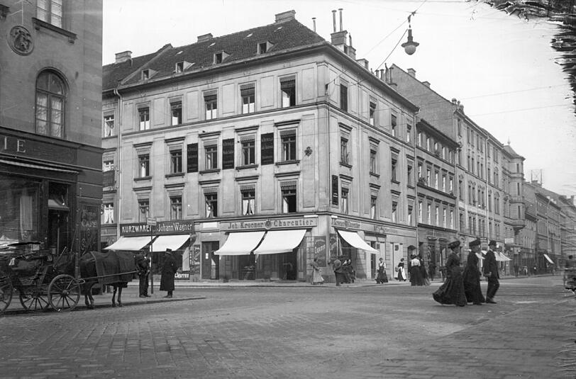 Eine Aufnahme von 1910: Hier trifft die Amalien- auf die Theresienstraße. Dort gab es unter anderem einen Kurzwarenladen und einen Schlachter. Links angeschnitten: das renommierte Café Stefanie, ein bevorzugter Treffpunkt des literarischen Münchens vor dem ersten Weltkrieg.