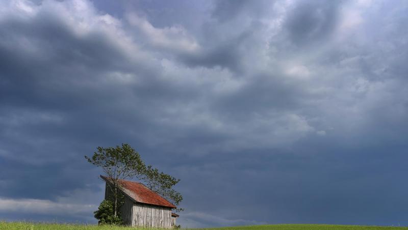 Dunkle Regenwolken ziehen über eine Holzhütte auf einer Wiese hinweg. Foto: Karl-Josef Hildenbrand/dpa/Archivbild Dunkle Regenwolken ziehen über eine Holzhütte auf einer Wiese hinweg. Foto: Karl-Josef Hildenbrand/dpa/Archivbild