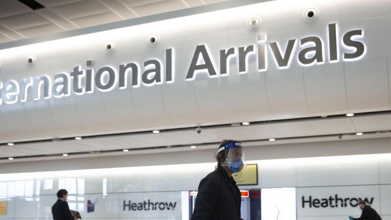 Ein Fluggast mit Mundschutz und Visier geht durch den Flughafen Heathrow. Ein Fluggast mit Mundschutz und Visier geht durch den Flughafen Heathrow.