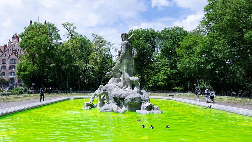 Grün gefärbtes Wasser ist in der Innenstadt im Neptunbrunnen zu sehen.