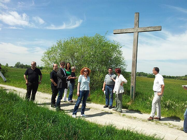 Grünen-Fraktionschefin Margarete Bause (M.) vor einem Kreuz. Hier wird der Wachtelkönig vertrieben.