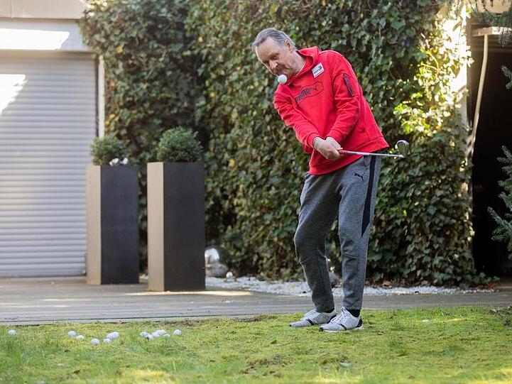 Peter Neururer übt in seinem Garten Golf.