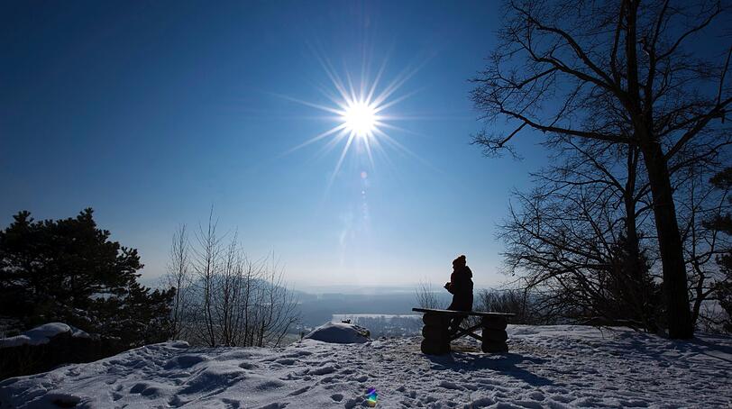 Eine Spaziergängerin schaut während einer Wanderung von dem Tafelberg "Kleiner Bärenstein" bei Naundorf über die Landschaft der Sächsischen Schweiz. Laut Wettervorhersage soll auch in den kommenden Tagen die Sonne scheinen, auch die Temperaturen bleiben weiterhin weit unter dem Gefrierpunkt.